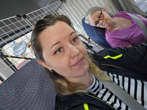       Two people taking a selfie inside a bus.
  
