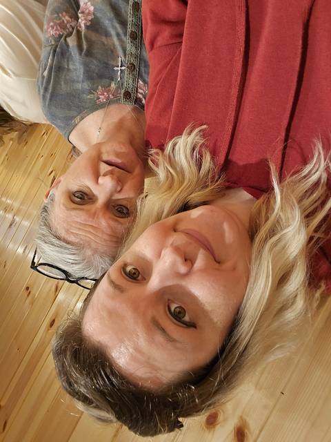       Two people taking a selfie indoors with wooden walls.
  