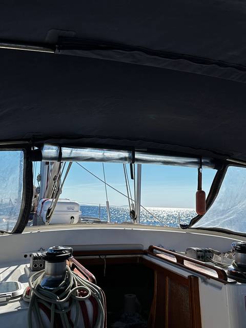       View from inside a boat cabin looking out at the sea.
  