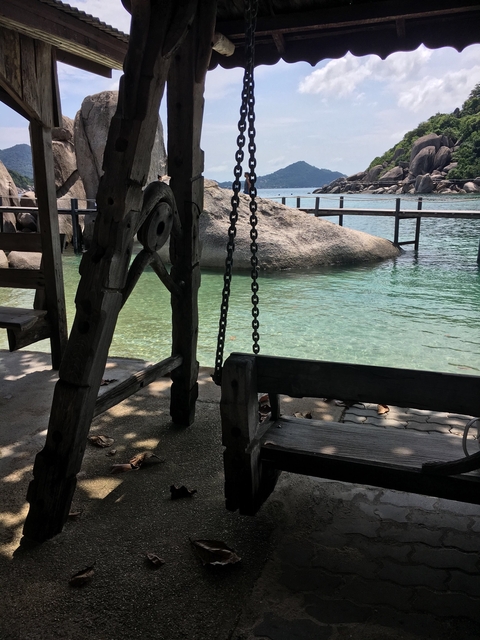       Wooden swing overlooking a clear water lake.
  