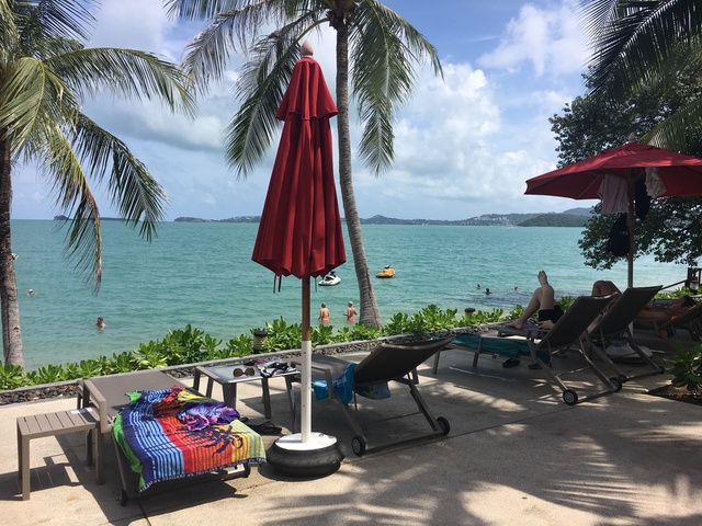       Beachfront with loungers and umbrellas facing the sea.
  