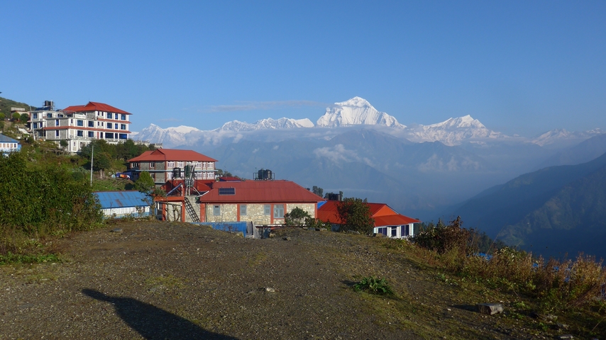 Scenic view of snow-capped mountains and buildings.