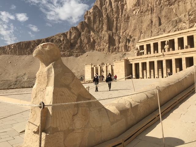 Ancient Egyptian temple with a large falcon statue.