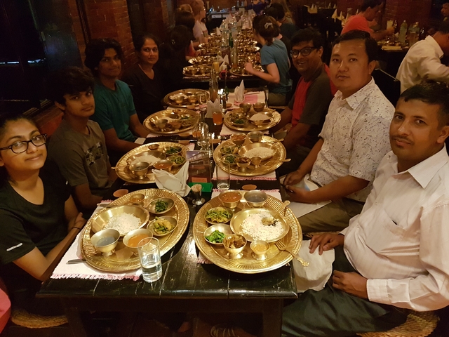 Group of people dining with traditional dishes on table.