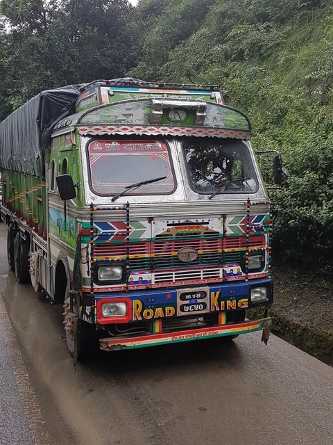 Front of a brightly painted truck on a road.