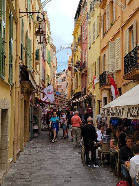       Bustling street scene with colorful buildings and tourists.
  