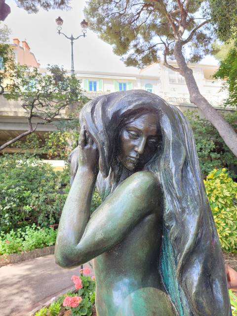       Bronze statue of a woman with long hair.
  