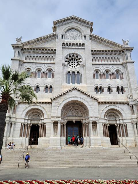       Large cathedral with intricate facade and people outside.
  