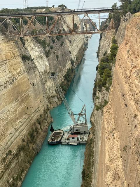       Canal flanked by steep cliffs with a ship.
  