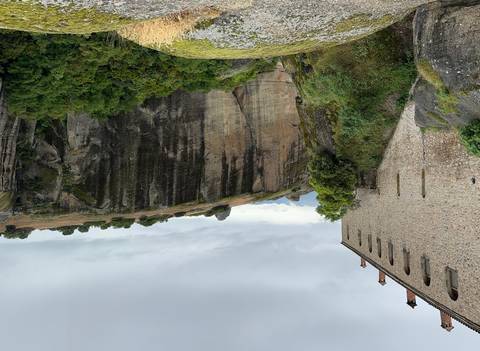      Steep rock formations surrounded by greenery.
  