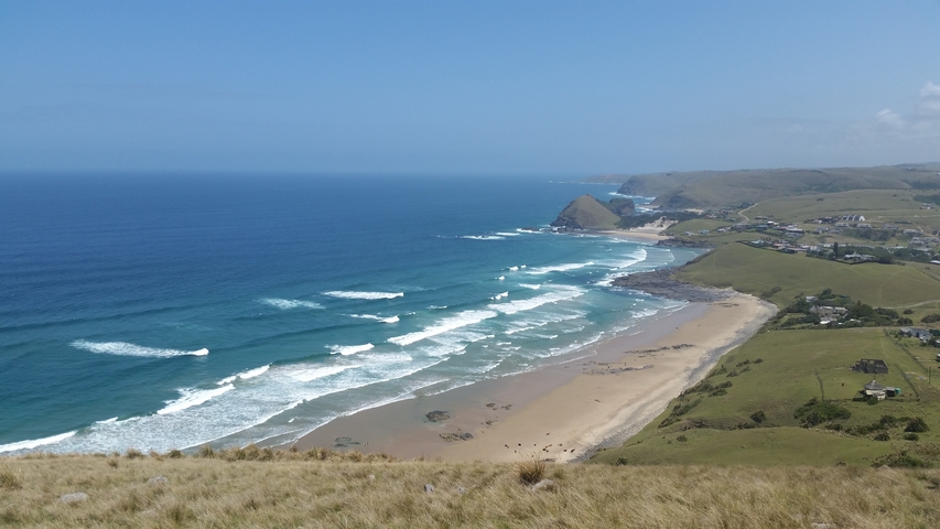 Aerial view of a beach with waves crashing on the shore.