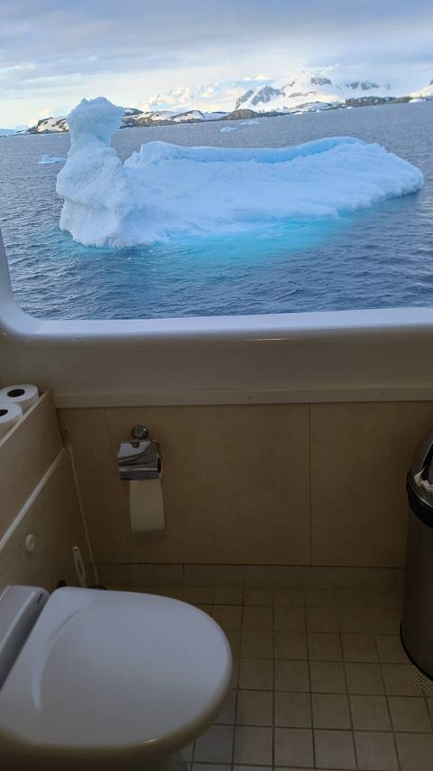 Boat interior view with small icebergs visible outside the window.