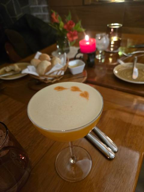       Close-up of a cocktail on a wooden table during a meal.
  