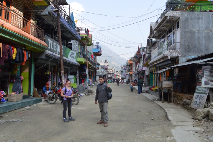       Busy street with people, shops, and street signs.
  