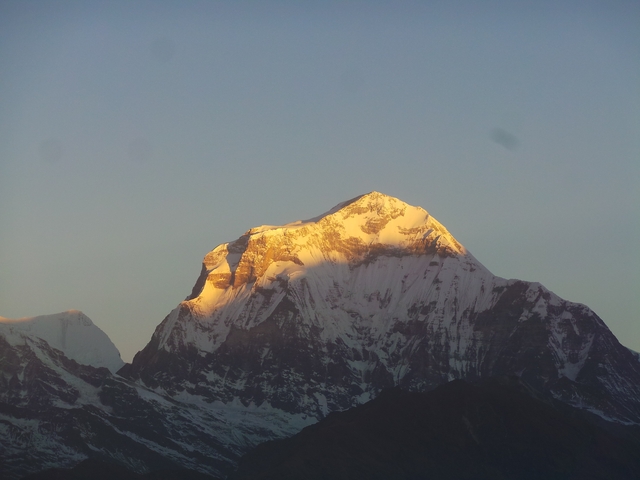       Golden hue on a snow-capped mountain peak.
  