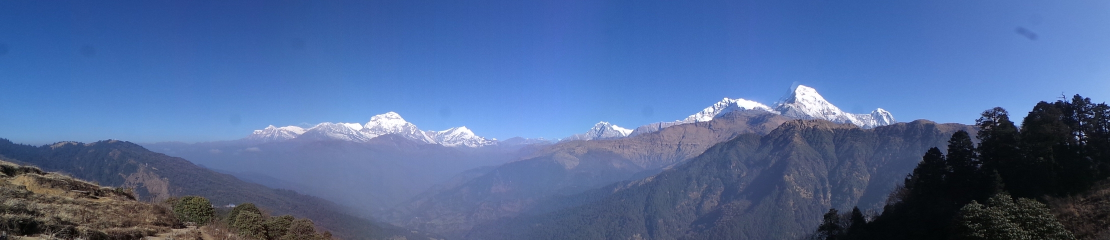       Panoramic mountain range with clear blue sky.
  