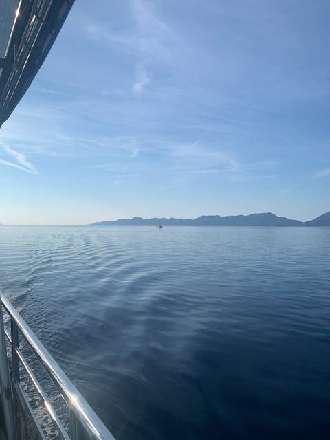 A distant mountain view over calm waters.