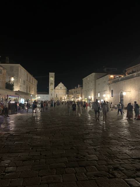 A lively night scene with a historic building.