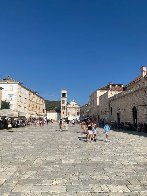 Square with people and a tower in the background.