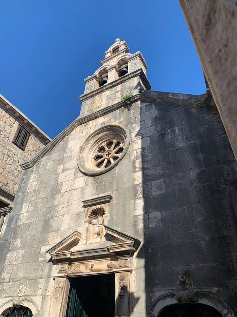 Historic stone church facade with arches.