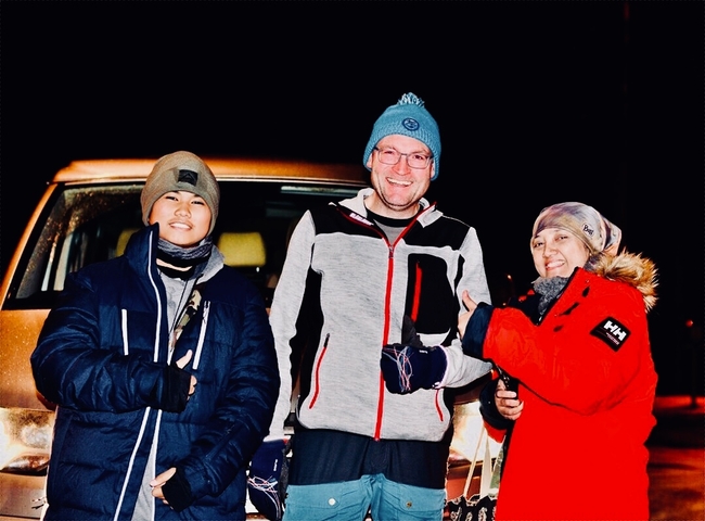       Three people posing in winter clothing.
  