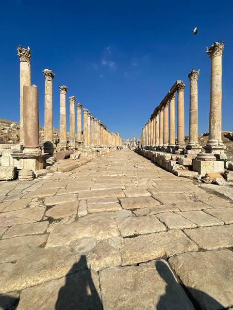       Ancient ruins with colonnades and blue sky.
  