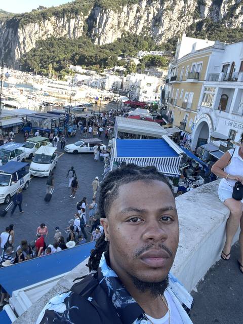       Selfie with a busy port and hills in the background.
  
