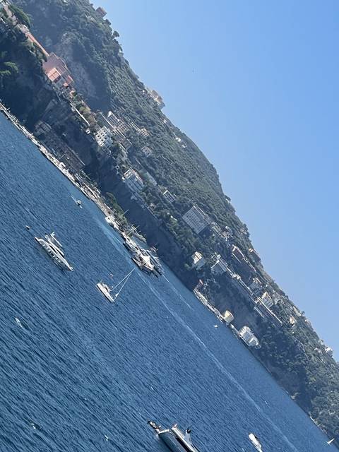       Hills and sea with buildings along the coast.
  