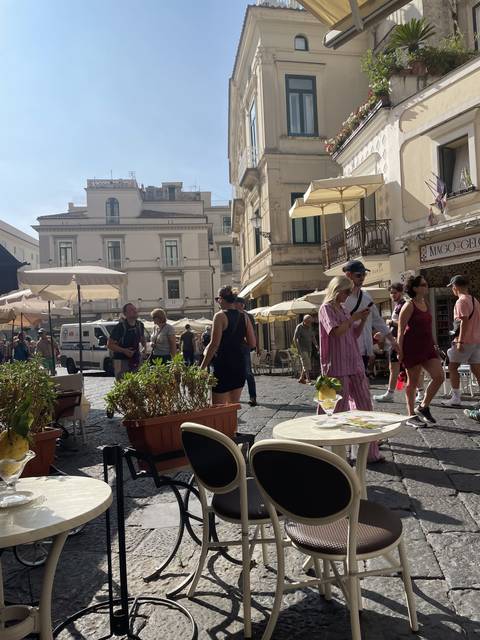       Outdoor cafe setting in a lively town square.
  