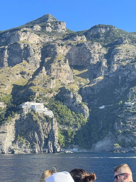 Coastal cliffside with buildings overlooking the sea.