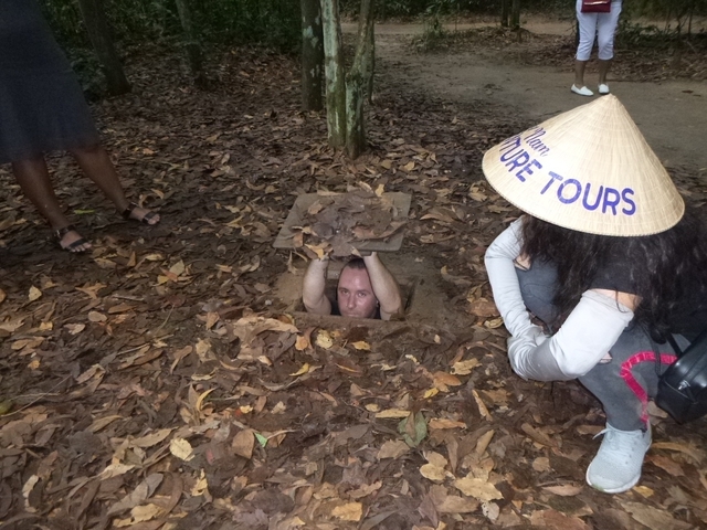       A person emerging from a tunnel with a local hat.
  