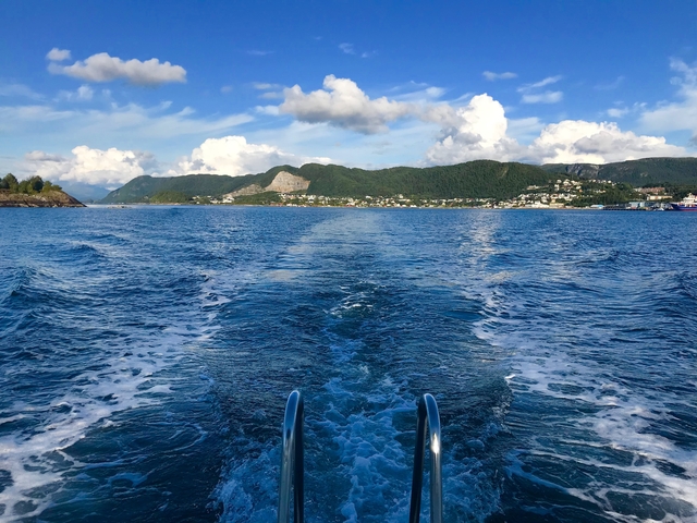 View from a boat on the open sea with mountains.