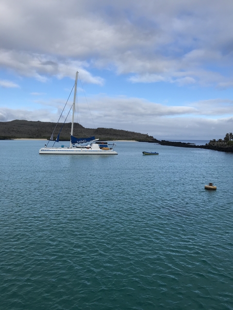       A sailboat anchored on a calm sea.
  