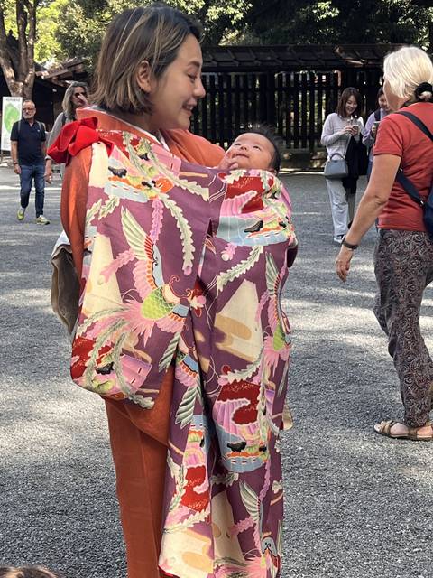      Adult holding child both wearing traditional kimonos.
  