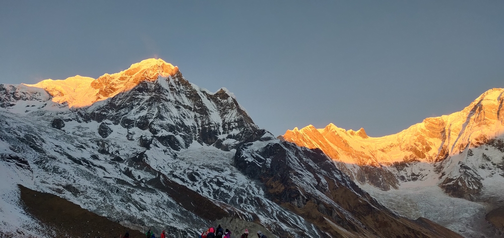       Mountain peaks at sunrise with orange glow.
  