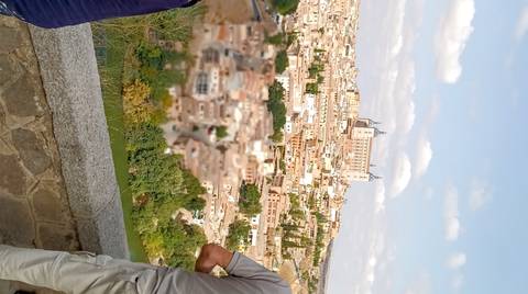 An aerial view of a historic town with a person in the foreground.