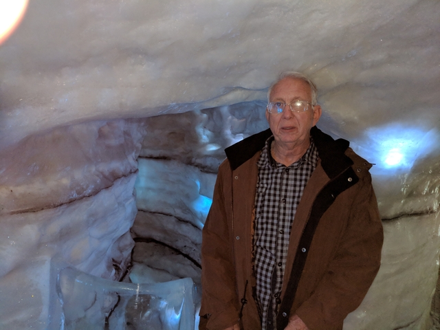      Man posing in an ice cave.
  