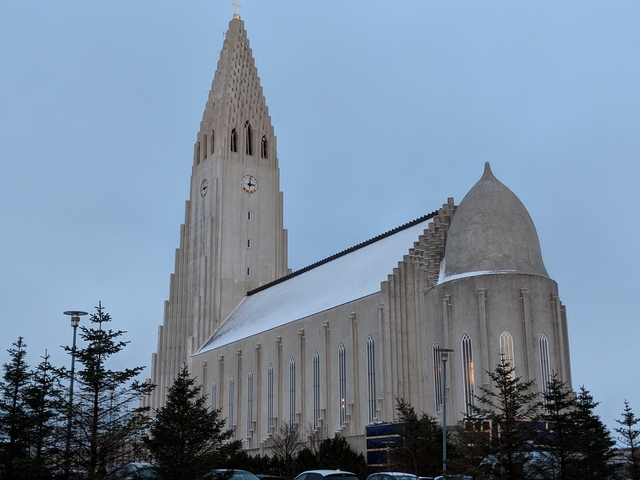       Hallgrímskirkja church in Reykjavik with a snowy roof under a gray sky.
  