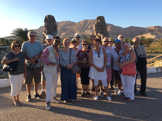 Group of people standing in front of a mountainous landscape.