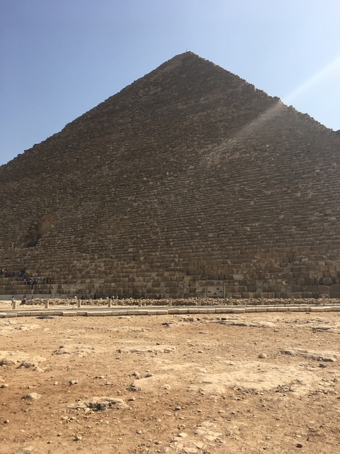 Base of a large pyramid with small figures for scale.