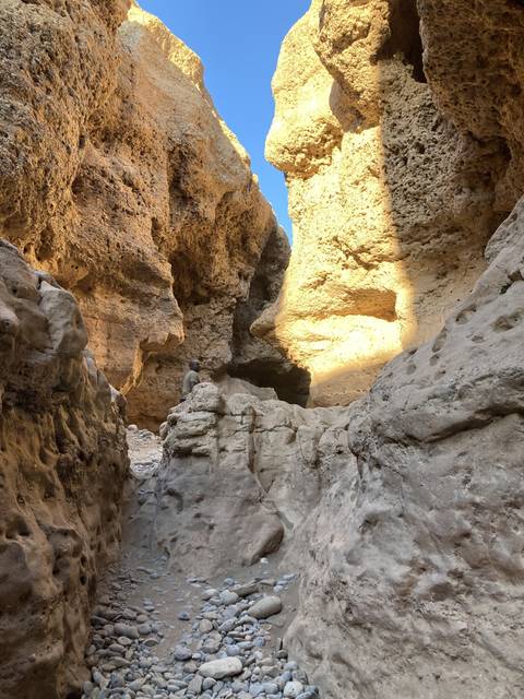       Interior view of a rock cave with light streaming in.
  