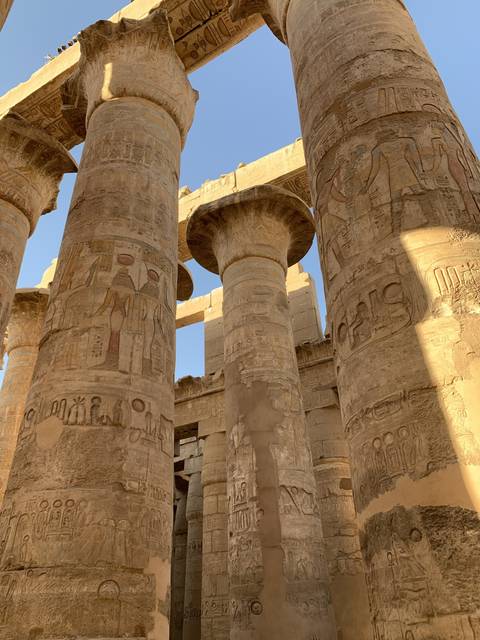Ancient columns with engravings and bright blue sky.