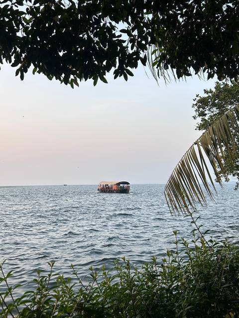      Boat on a large body of water with trees in the distance.
  