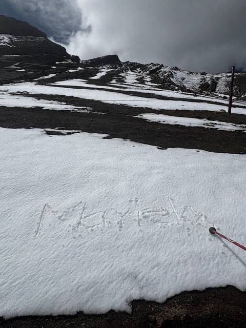 Snow-covered mountain slope with writing in the snow
