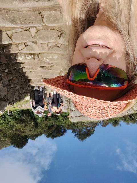 Selfie on stone steps with a hat and sunglasses.
