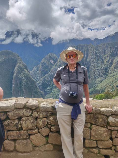 Man standing on stone terrace with scenic view.