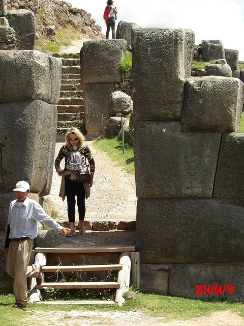 Person standing under an ancient stone structure.