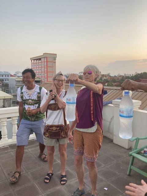 A group of people enjoying a rooftop view with bottled drinks.