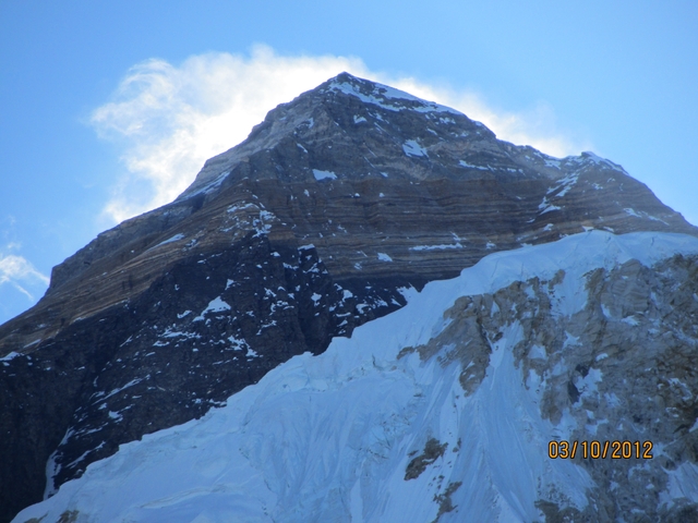       A snowy mountain peak under clear blue sky.
  