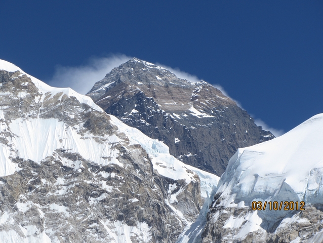       Mountain peak with snow and clouds.
  